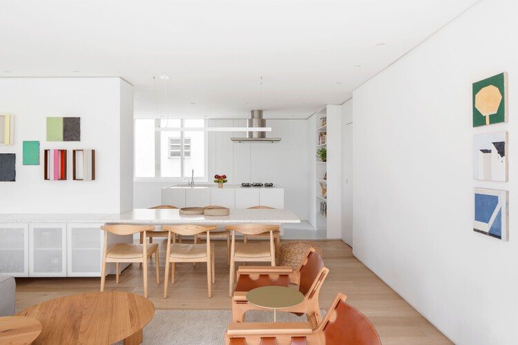 A modern kitchen and dining room featuring wooden furniture, showcasing a blend of contemporary design and historic architecture.