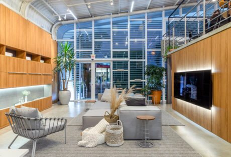 A modern living room featuring elegant wood paneling and expansive glass walls, blending indoor comfort with outdoor views.