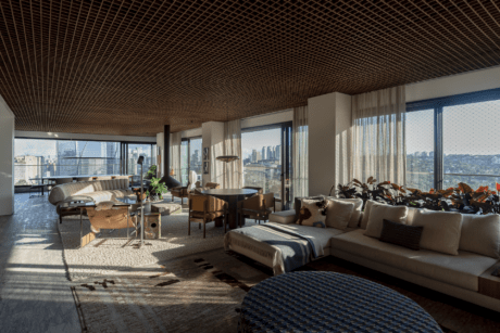 Integrated living area at CRR | Arborea by Triplex Arquitetura, with modular sofa, dining table, suspended fireplace and continuous windows over São Paulo in Itaim Bibi